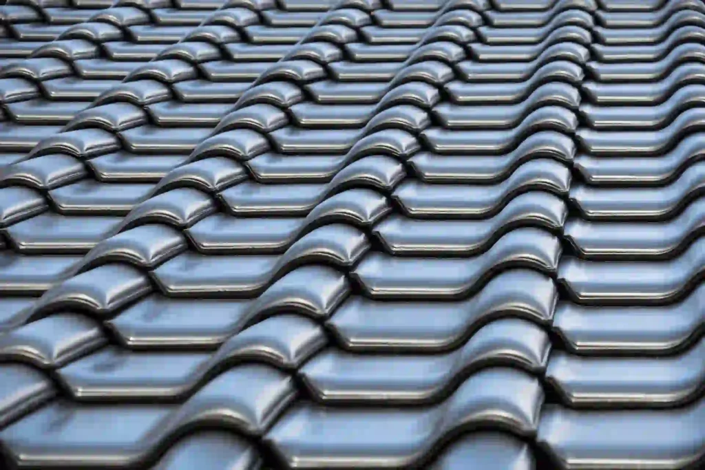 Metal Roof vs Shingle Massachusetts, Close-up texture of glossy black ceramic S-shaped roof tiles arranged in rows.