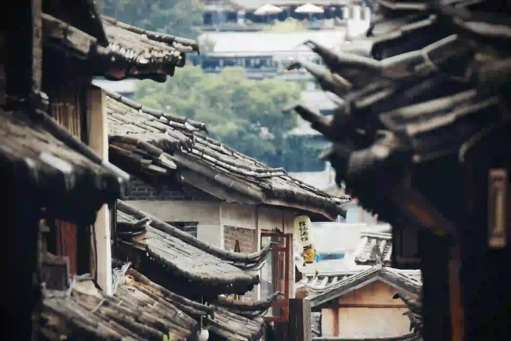 Commercial Roofing Newton MA, Traditional Chinese village rooftops with upturned tiled eaves and a hanging wooden sign.